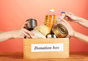 Donation box with food on red background close-up