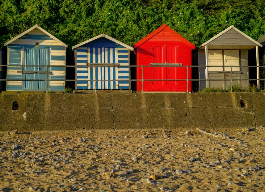 Row of colorful beach huts along the promenade and seafront of Cromer beach