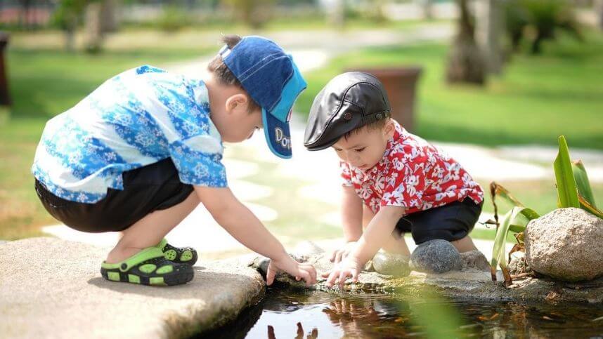 2 boys looking at a pond